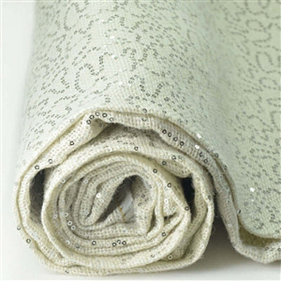 Rolled beige fabric with sequins, showcasing a textured pattern.